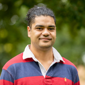 Image of Franco, smiling and wearing a red and navy striped polo jumper.